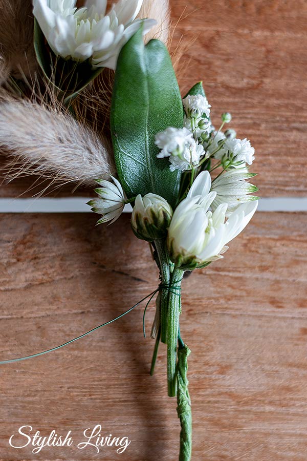 Die verschiedenen Blumen abwechseln entlang des Drahtkranzes mit Wickeldraht umwickeln